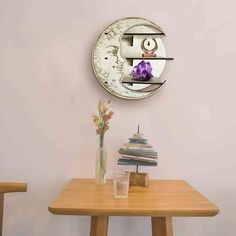 a wooden table topped with a vase filled with flowers next to a wall mounted clock