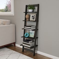 a leaning shelf with books and pictures on it