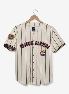 Get ready for game day in Disney fashion with this Rescue Rangers baseball jersey! Featuring "Rescue Rangers" lettering on the front  the back of this jersey includes "Chip 89" lettering. With a striped background and a Chip and Dale patch on one sleeve  this shirt is perfect for a trip to the Disney Parks.A BoxLunch Exclusive!Recycled polyesterListed in unisex sizesWash cold with like colors; dry lowImported Disney November, Rescue Rangers, Rangers Baseball, Baseball Jersey Men, Chip And Dale, Disney Fashion, Striped Background, Mens Button Up, Baseball Jersey