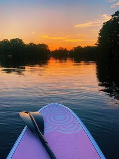 a paddle board sitting on top of a body of water with trees in the background