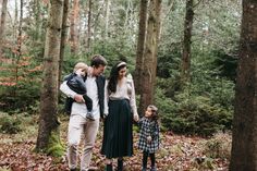 a family walking through the woods holding hands