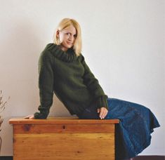 a woman sitting on top of a wooden box