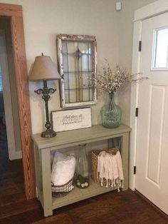 an entryway with a shelf, mirror and lamp on it's side table