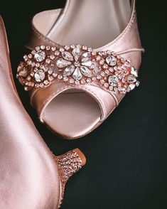 a pair of pink high heeled shoes sitting on top of a black surface