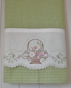 a green and white kitchen towel with flowers on it