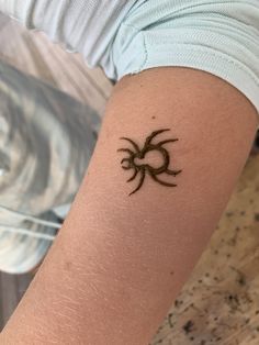 a woman's arm with a tattoo on it that is shaped like a spider