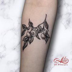 a black and white tattoo on the leg of a woman's arm with fruit