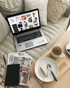 an open laptop computer sitting on top of a wooden table next to a cup of coffee