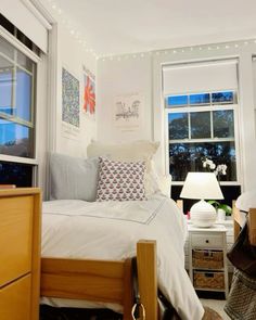 a bedroom with white walls and lights on the window sill above the bed is decorated in neutral colors