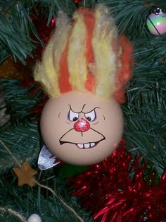 an ornament hanging from a christmas tree decorated with clown face hair and nose