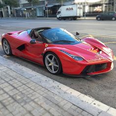 the red sports car is parked on the side of the road