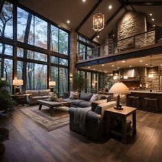 a living room filled with lots of furniture and large windows over the top of it