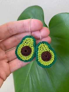 a pair of green and brown crocheted earrings with an avocado design