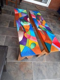 two wooden benches sitting on top of a tiled floor