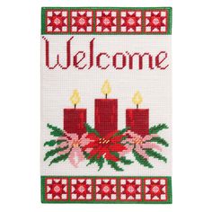 a welcome sign with three candles and holly wreaths on the front, in red and green