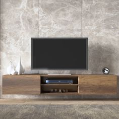 an entertainment center with a flat screen tv mounted on it's side, in front of a stone wall