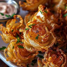 some onion rings on a plate with dipping sauce