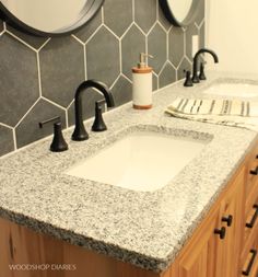 two sinks in a bathroom with marble counter tops and black faucets on the wall