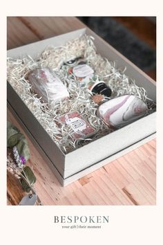 an open box that has some items inside of it on a table next to a plant