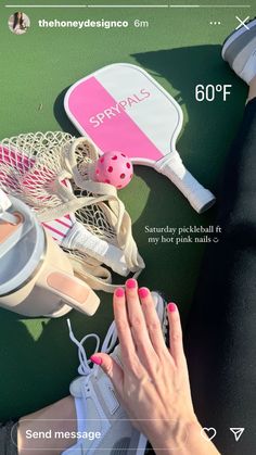 a woman's hand with pink nail polish on her nails next to tennis racquets