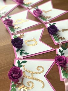 purple roses and gold foil are on top of cards with the number five in them