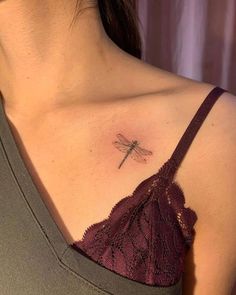 a woman's chest with a small tattoo of a dragonfly on her left side