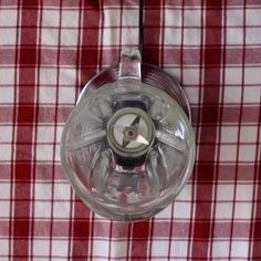 a red and white checkered table cloth with a glass blender on the top