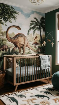 a baby's room decorated in green and white with dinosaurs on the wall, including a dinosaur crib