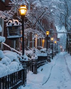 a street light covered in snow next to buildings