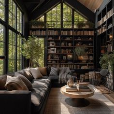 a living room filled with lots of furniture and bookshelves next to a window