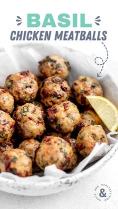 a white bowl filled with meatballs next to a lemon wedge