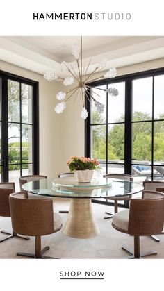 a dining room table with chairs and a chandelier hanging from it's ceiling