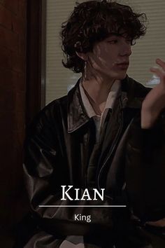 a man sitting down with his hand up in front of him and the words klian king on it