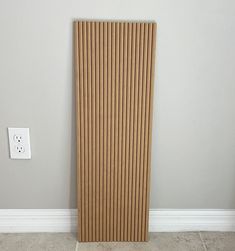 a wooden radiator sitting next to a wall with a light switch on it