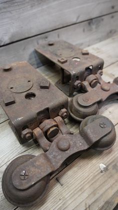 an old pair of metal latches sitting on top of a wooden floor next to each other