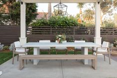 a white table and chairs under an outdoor gazebo