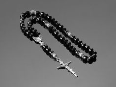 This unique handmade rosary, crafted from black faceted onyx, is a perfect unisex gift for any occasion, including birthdays or as a personal spiritual amulet. The 53 onyx beads offer comfort and strength during prayer, guiding the faithful on their spiritual journey. Each faceted bead reflects light, symbolizing the depth and beauty of faith. Durable and crafted with care, this rosary highlights individuality and religious devotion while providing a lasting companion for prayer. MATERIALS 📿Catholic Rosary Natural Black Faceted Onyx 53 beads. Stones - Natural Faceted Black Onyx Connector - Virgin Mary - jewelry fittings plated with 999 sterling silver Stainless steel cross SIZE Our Father beads - jewelry fittings inlaid with cubic zirconia - 10 mm/0.39 IN. Between the Onyx beads there are Pocket Prayer, Personalized Rosary, Handmade Rosary, Rosary Beads Catholic, Mary Necklace, Virgin Mary Necklace, 12 Stones, Catholic Rosary, Catholic Jewelry