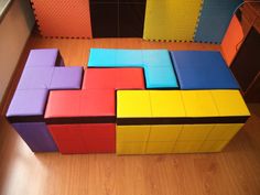 several different colored blocks sitting on top of each other in front of a wall and floor