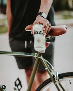 a close up of a person on a bike with a bottle of liquid in their hand