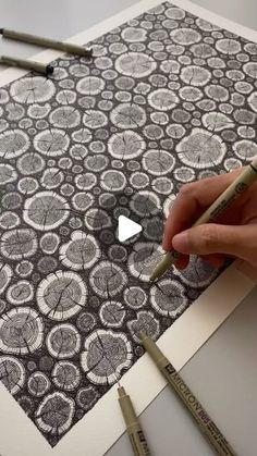 someone is drawing circles on a piece of paper with crayons and pencils