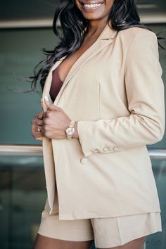 This polished blazer and shorts set proves that power and femininity go hand in hand. The suit features a blazer with a lapel neckline, long sleeves, and faux pockets paired with wide leg shorts for a comfortable fit Chic Beige Blazer With Suit Collar, Chic Beige Blazer With Notch Lapel, Chic Semi-formal Pantsuit With Notch Lapel, Chic Suits With Notch Lapel And Button Cuffs, Chic Beige Single-breasted Suit, Chic Long Sleeve Pantsuit For Business Casual, Chic Single Button Blazer For Night Out, Chic Beige Notch Lapel Blazer Dress, Chic Single Breasted Pantsuit For Business Casual