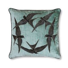 a blue pillow with black birds on it