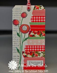 a tag with flowers on it sitting on top of a bookmark that says happy birthday