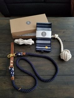 a blue and white striped leash with rope on the ground next to a brown box