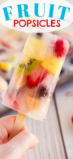 a popsicle is being held up to the camera with fruit on it and text overlay that reads, fruit popsicles