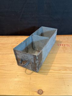 an old metal box sitting on top of a wooden table