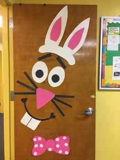 a door decorated to look like a bunny with a pink bow tie on it's head