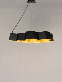 a black and yellow chandelier with five lights hanging from it's sides