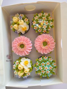 the cupcakes in the box are decorated with flowers