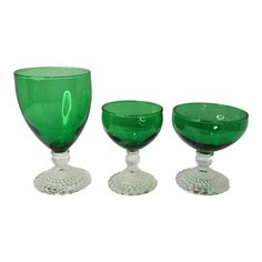 three green glass goblets sitting next to each other